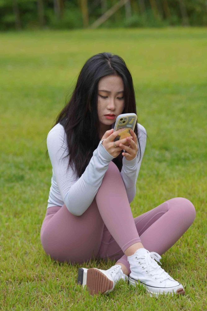 坐在草地玩手机的瑜伽姑娘【733P】04012-草莓街拍